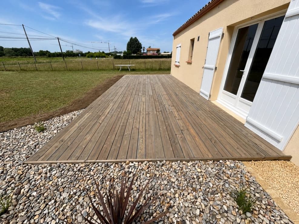 Grande terrasse bois avec massif minéral de galets