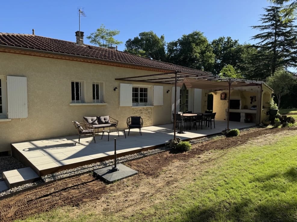 Terrasse dallée avec pergola et salon de jardin